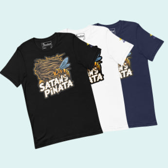 Flat lay of three 'Satan's Pinata' t-shirts in black, white, and navy colors.